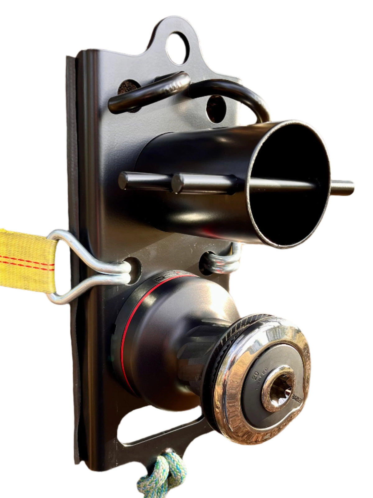 A compact rigging system with a black Harken Radial 20 self-tailing winch mounted on a fixed bollard, secured by a rigging plate and rope.